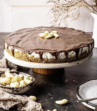 Veganer Cashew-Topfenkuchen mit Karamell-Schokosauce