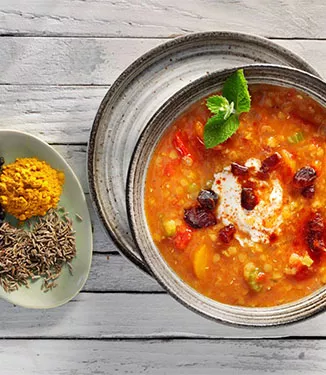 Roter Linseneintopf mit Gewürzjoghurt und Dattel-Würfeln